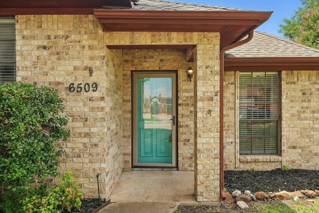 6509 Parkridge Dr, Sachse, TX 75048 - view of exterior entry with roof with shingles and brick siding