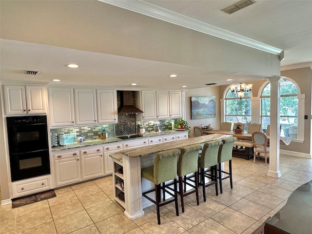 13449 S Hillcreek Rd, Whitehouse, TX 75791 - kitchen with ornamental molding, black appliances, wall chimney range hood, a chandelier, and tasteful backsplash