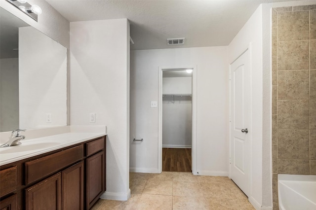 1206 Lombardy Dr, Princeton, TX 75407 - bathroom with vanity, tile patterned flooring, a walk in closet, and baseboards
