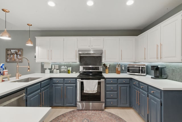 945 Lake Ridge Dr, Azle, TX 76020 - kitchen with stainless steel appliances, a sink, blue cabinetry, under cabinet range hood, and white cabinets