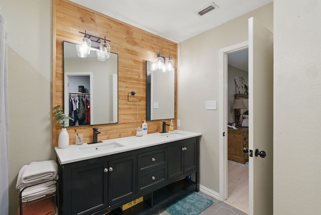 945 Lake Ridge Dr, Azle, TX 76020 - bathroom featuring wooden walls, double vanity, and a walk in closet