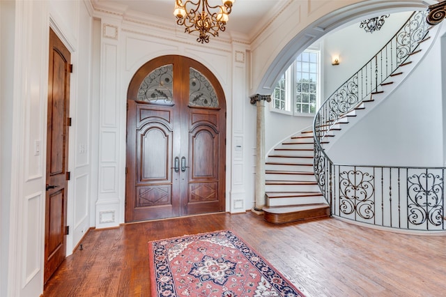 2145 Grand View Ct, Cedar Hill, TX 75104 - foyer entrance with a chandelier, dark wood-style floors, arched walkways, stairs, and a decorative wall
