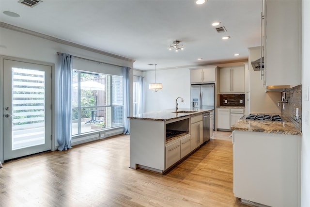 3719 Douglas Ave, Dallas, TX 75219 - kitchen with ornamental molding, plenty of natural light, light wood finished floors, stainless steel appliances, and recessed lighting