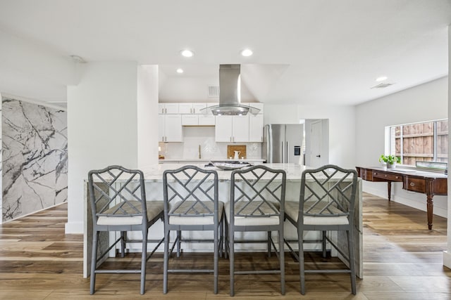 6607 Leameadow Dr, Dallas, TX 75248 - kitchen featuring stainless steel refrigerator with ice dispenser, island exhaust hood, a kitchen breakfast bar, white cabinets, and recessed lighting