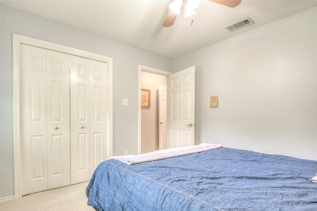2202 Burgundy Dr, Carrollton, TX 75006 - bedroom featuring light carpet, ceiling fan, a closet, and a textured ceiling