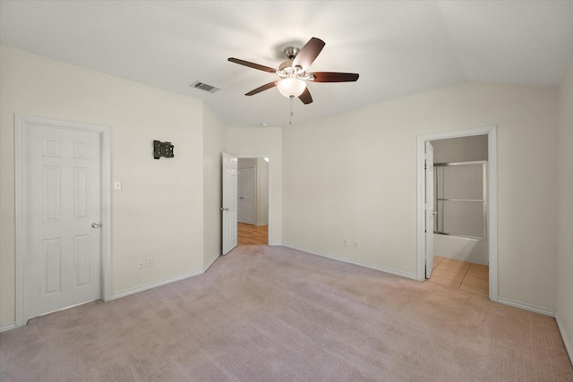 143 Doe Run Rd, Gun Barrel City, TX 75156 - unfurnished bedroom with light carpet, baseboards, lofted ceiling, a ceiling fan, and ensuite bath