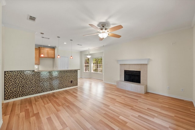 143 Doe Run Rd, Gun Barrel City, TX 75156 - unfurnished living room featuring light wood-style floors, ceiling fan, baseboards, a tile fireplace, and crown molding