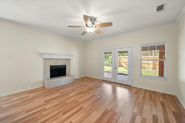 143 Doe Run Rd, Gun Barrel City, TX 75156 - unfurnished living room featuring ceiling fan, light wood-style flooring, french doors, crown molding, and a tile fireplace