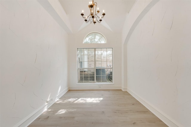 8209 Shoshoni Dr, Arlington, TX 76002 - empty room with a chandelier, vaulted ceiling, wood finished floors, and baseboards