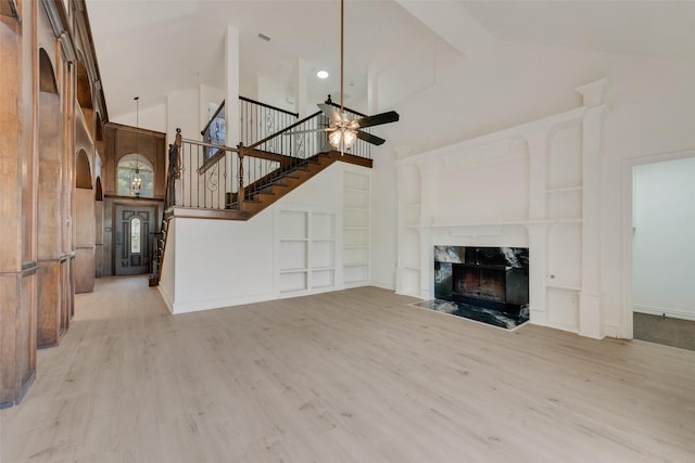 8209 Shoshoni Dr, Arlington, TX 76002 - unfurnished living room with high vaulted ceiling, ceiling fan, built in features, stairway, and wood finished floors