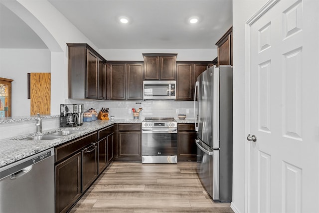 3128 Autry Rd, Lorena, TX 76655 - kitchen with appliances with stainless steel finishes, a sink, arched walkways, dark brown cabinets, and recessed lighting