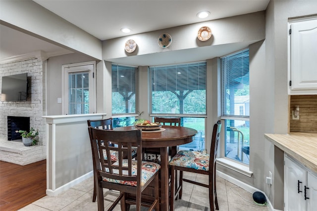 4920 Brookhollow Dr, Sachse, TX 75048 - dining space featuring plenty of natural light, light tile patterned floors, a brick fireplace, recessed lighting, and baseboards