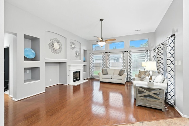 313 Owen Oaks Dr, Lake Dallas, TX 75065 - living area with ceiling fan, built in shelves, wood finished floors, and a glass covered fireplace