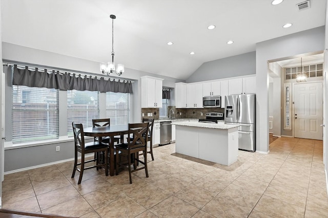 313 Owen Oaks Dr, Lake Dallas, TX 75065 - kitchen featuring stainless steel appliances, a chandelier, a center island, lofted ceiling, and decorative backsplash