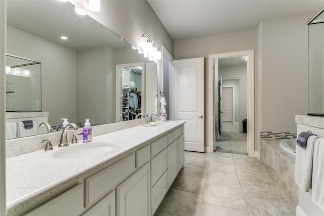 6929 Heather Ln, North Richland Hills, TX 76182 - bathroom featuring double vanity, a bath, a walk in closet, and tile patterned flooring