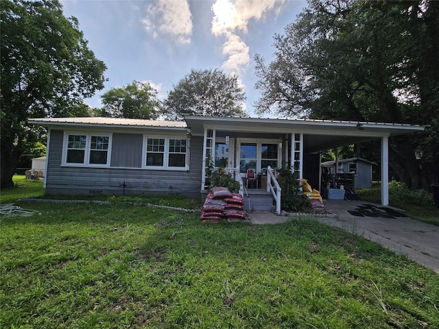 703 Jeanell St, Quitman, TX 75783 - view of front of home with covered porch, metal roof, a front yard, and driveway