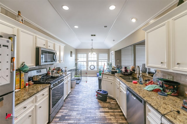 6008 Pepperwood Cir, Bossier City, LA 71111 - kitchen featuring stainless steel appliances, a sink, lofted ceiling, a chandelier, and white cabinets
