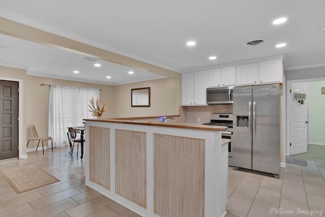 9346 Shartel Dr, Shreveport, LA 71118 - kitchen with stainless steel appliances, ornamental molding, recessed lighting, light countertops, and white cabinetry