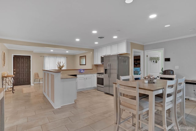 9346 Shartel Dr, Shreveport, LA 71118 - kitchen with stainless steel appliances, a peninsula, white cabinets, crown molding, and recessed lighting