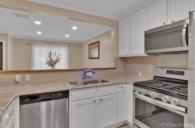 9346 Shartel Dr, Shreveport, LA 71118 - kitchen featuring appliances with stainless steel finishes, ornamental molding, backsplash, white cabinets, and recessed lighting