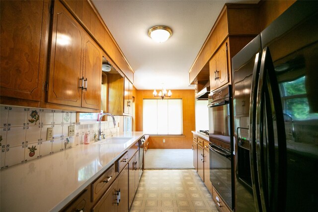 10210 E Lk Highlands, Dallas, TX 75218 - kitchen featuring black appliances, a sink, brown cabinetry, a chandelier, and light countertops