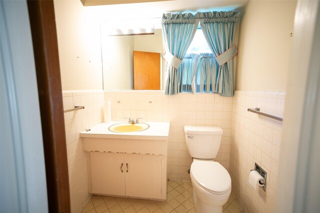 10210 E Lk Highlands, Dallas, TX 75218 - half bath featuring toilet, vanity, tile walls, tile patterned flooring, and a wainscoted wall