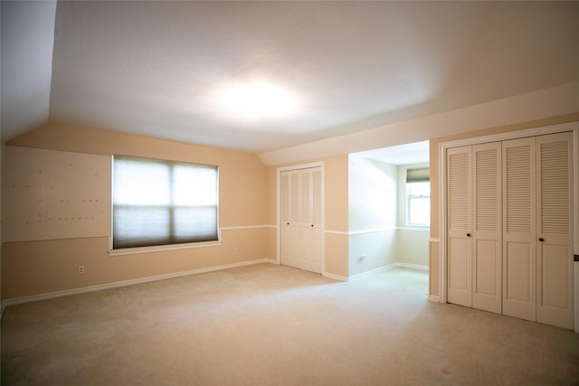 10210 E Lk Highlands, Dallas, TX 75218 - unfurnished bedroom featuring multiple closets, light carpet, lofted ceiling, and baseboards