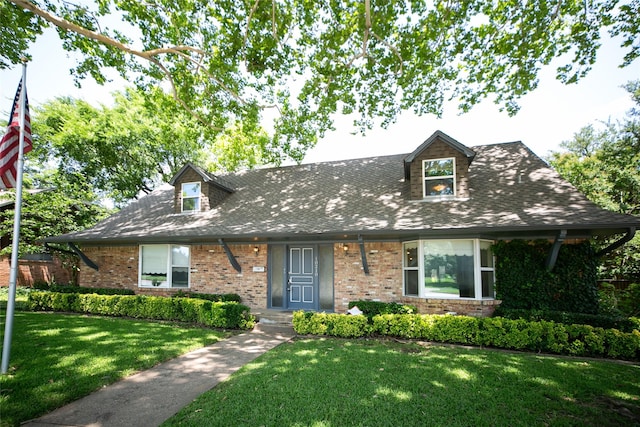 10210 E Lk Highlands, Dallas, TX 75218 - new england style home featuring a front yard, brick siding, and roof with shingles