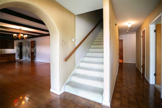 10210 E Lk Highlands, Dallas, TX 75218 - staircase with a chandelier, beamed ceiling, baseboards, arched walkways, and parquet flooring
