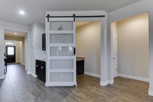 1541 Seabiscuit Dr, Granbury, TX 76049 - kitchen featuring a barn door, dark wood-style floors, baseboards, light stone countertops, and recessed lighting