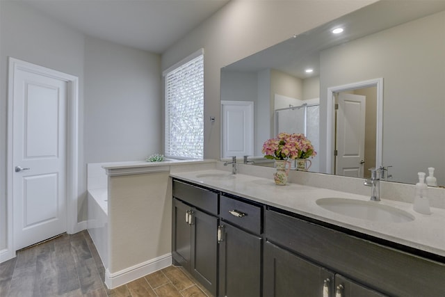 1541 Seabiscuit Dr, Granbury, TX 76049 - full bath with double vanity, wood finished floors, a garden tub, a shower stall, and baseboards
