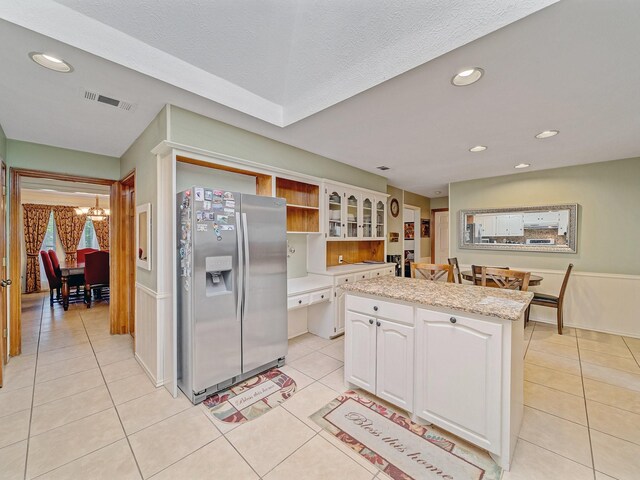 4640 Versailles Ln, Plano, TX 75093 - kitchen featuring stainless steel refrigerator with ice dispenser, open shelves, white cabinets, light tile patterned floors, and a chandelier