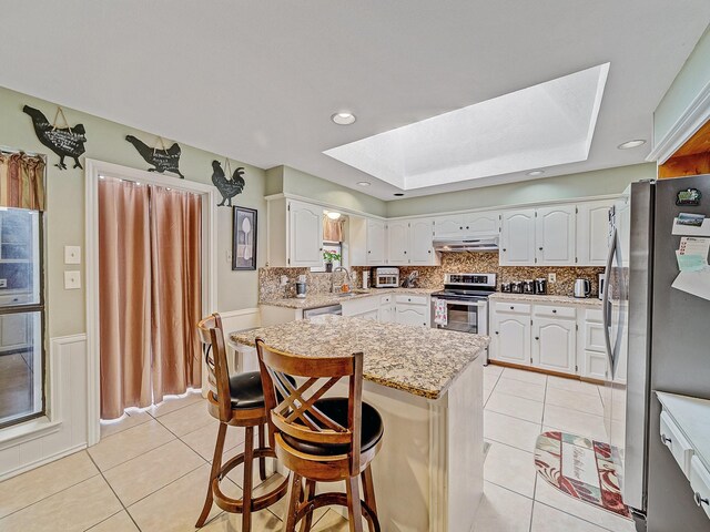 4640 Versailles Ln, Plano, TX 75093 - kitchen with a skylight, stainless steel appliances, light tile patterned floors, under cabinet range hood, and a sink
