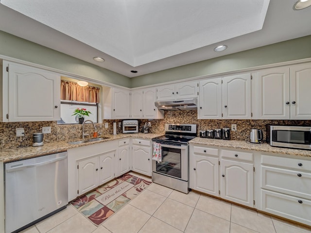 4640 Versailles Ln, Plano, TX 75093 - kitchen featuring appliances with stainless steel finishes, a sink, under cabinet range hood, decorative backsplash, and white cabinetry