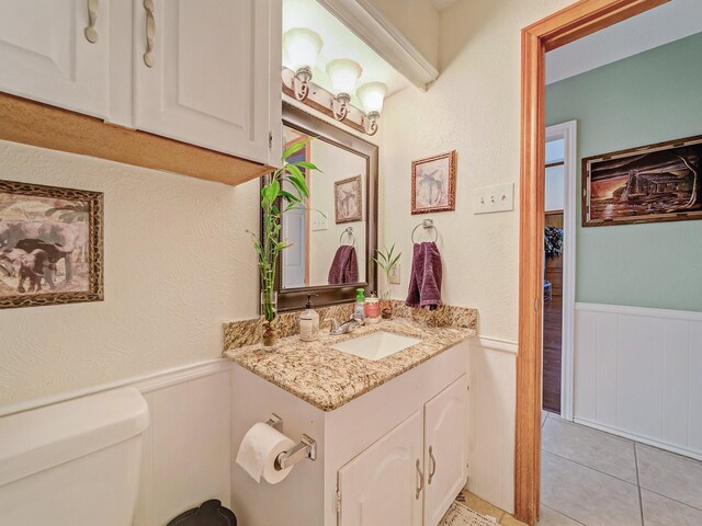 4640 Versailles Ln, Plano, TX 75093 - bathroom featuring wainscoting, toilet, vanity, and tile patterned flooring