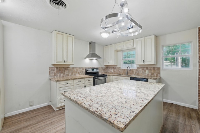 325 Belmont St, Hurst, TX 76053 - kitchen with stainless steel electric range oven, wall chimney range hood, light wood-type flooring, and decorative backsplash