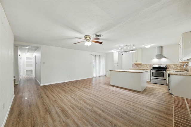 325 Belmont St, Hurst, TX 76053 - kitchen featuring stainless steel electric range oven, wall chimney exhaust hood, light wood-type flooring, a kitchen island, and white cabinetry