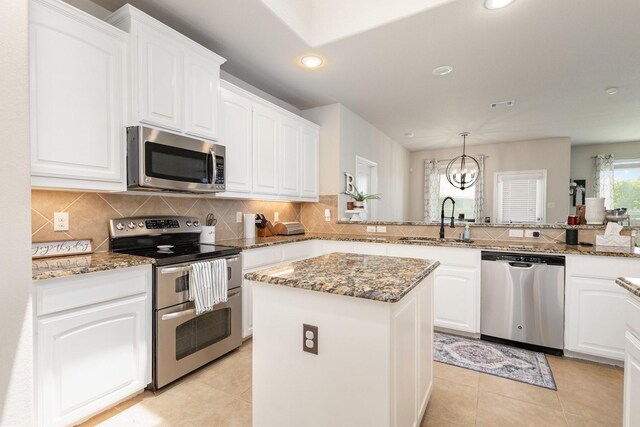 7609 Velvet Antler Trl, Arlington, TX 76002 - kitchen with appliances with stainless steel finishes, a sink, backsplash, a kitchen island, and white cabinets