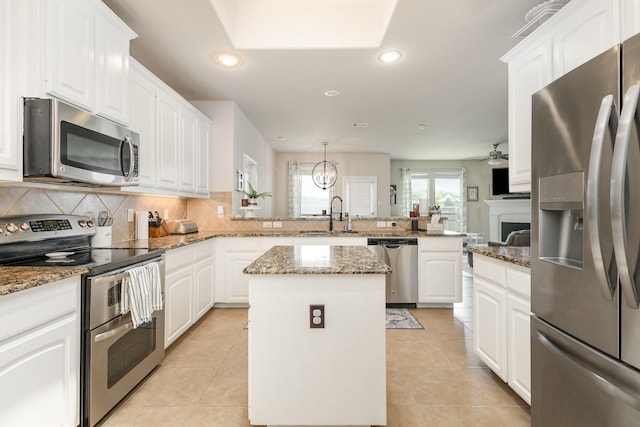 7609 Velvet Antler Trl, Arlington, TX 76002 - kitchen featuring stainless steel appliances, a peninsula, a sink, a kitchen island, and recessed lighting
