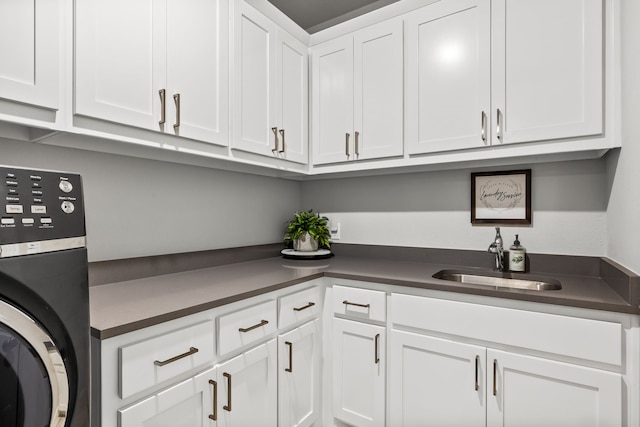 16471 Prairie Oak Rd, Frisco, TX 75033 - kitchen with washer / clothes dryer, a sink, dark countertops, and white cabinetry
