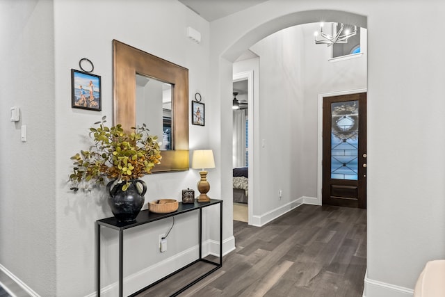 16471 Prairie Oak Rd, Frisco, TX 75033 - entryway with dark wood-type flooring, a chandelier, arched walkways, and baseboards
