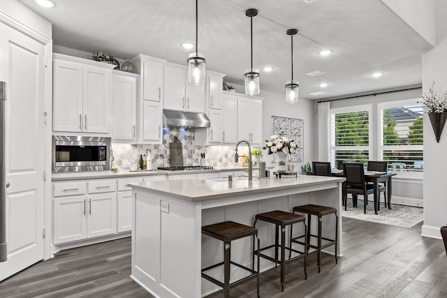 16471 Prairie Oak Rd, Frisco, TX 75033 - kitchen with stainless steel appliances, dark wood-style floors, under cabinet range hood, light countertops, and recessed lighting