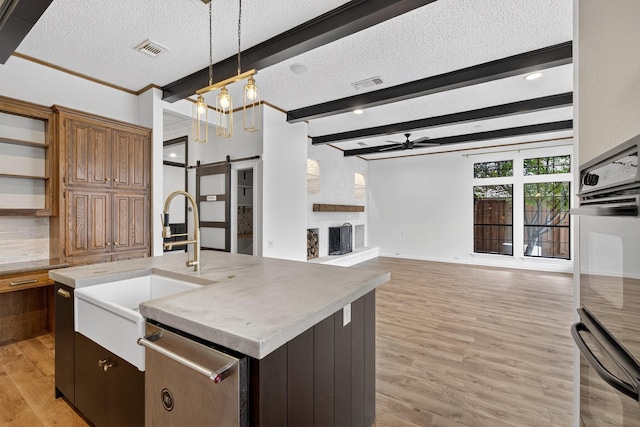 4000 Tumbril Ln, Plano, TX 75023 - kitchen with a barn door, ceiling fan, open floor plan, a sink, and a textured ceiling