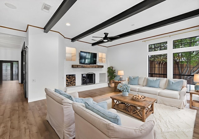 4000 Tumbril Ln, Plano, TX 75023 - living room featuring beamed ceiling, a ceiling fan, a fireplace with raised hearth, wood finished floors, and baseboards