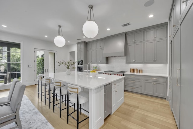 7141 Lyre Ln, Dallas, TX 75214 - kitchen featuring gray cabinets, premium range hood, backsplash, light countertops, and recessed lighting