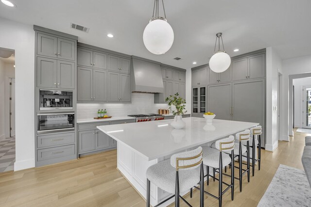 7141 Lyre Ln, Dallas, TX 75214 - kitchen featuring gray cabinets, custom range hood, decorative backsplash, recessed lighting, and light countertops