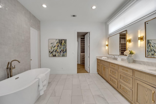 7141 Lyre Ln, Dallas, TX 75214 - full bathroom with a freestanding tub, double vanity, recessed lighting, and baseboards