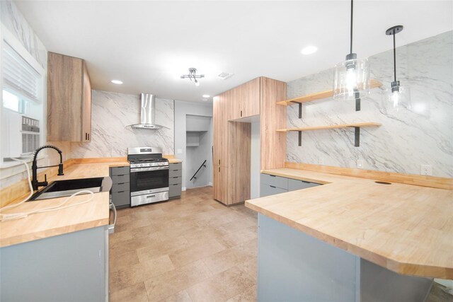 221 S 7th St, Jacksboro, TX 76458 - kitchen featuring stainless steel gas range, wooden counters, wall chimney exhaust hood, a sink, and open shelves