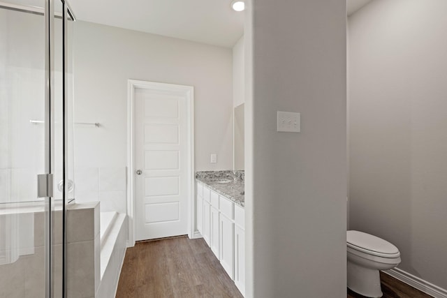 10605 Stag Ln, Fort Worth, TX 76036 - full bath with wood finished floors, vanity, a stall shower, toilet, and a garden tub