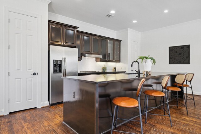 1120 Hemingway Ln, Irving, TX 75063 - kitchen featuring stainless steel fridge, under cabinet range hood, a sink, a kitchen breakfast bar, and dark wood-style floors